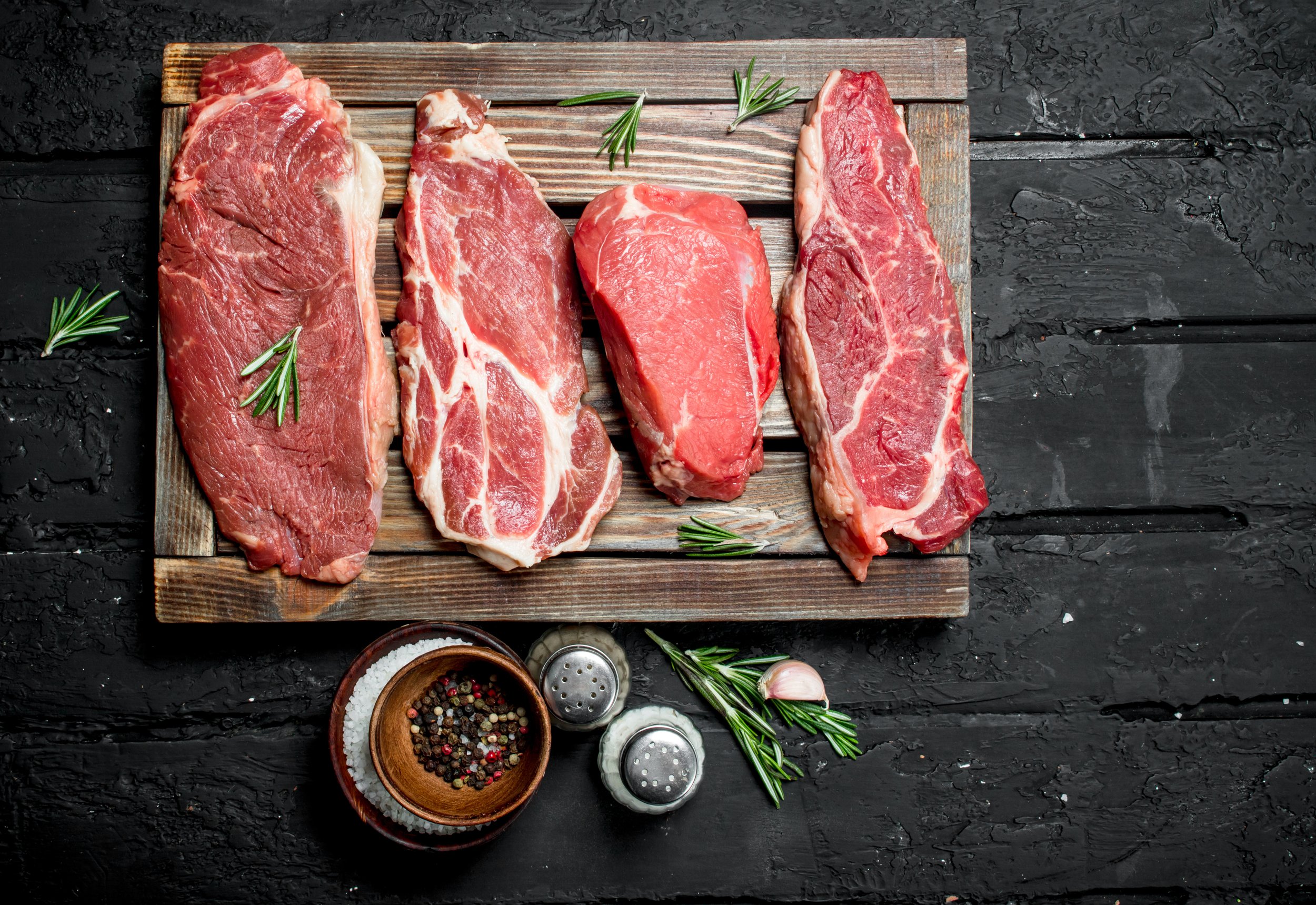 Raw meat. Pork and beef steaks on a tray with spices and rosemary sprig. Image placeholder indicating a photo is needed, typically used in web design or content management systems to signal missing visual content.